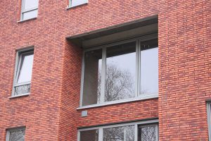 Grijs aluminium schrijnwerk contrastreert met hedendaagse appartementsbouw