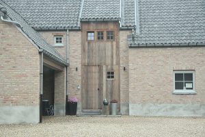 Houten voordeur in combinatie met houten raamprofielen