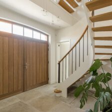 een trap in de inkom van een huis met een grote houten deur