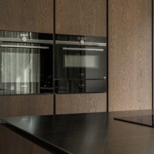 een keuken met een zwart aanrechtblad en oven